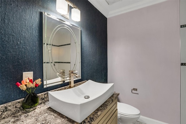 bathroom featuring toilet, vanity, and ornamental molding