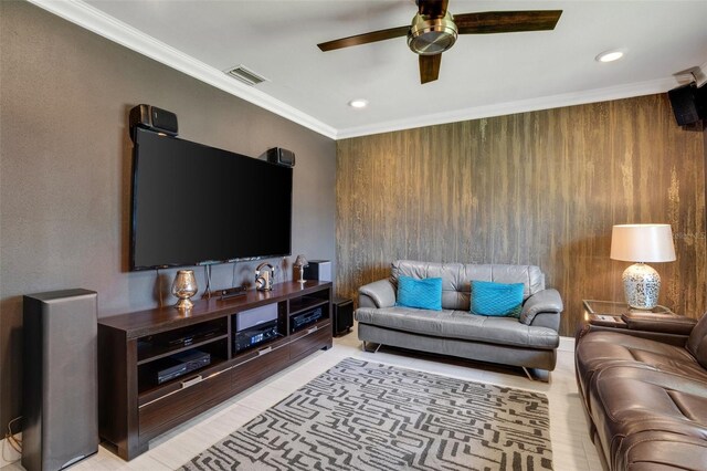 living room with wooden walls, ceiling fan, and crown molding