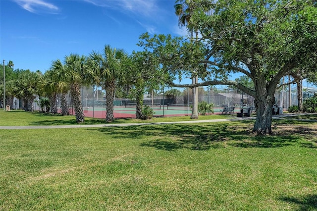 view of community featuring a lawn and tennis court