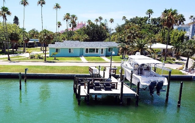 view of dock with a water view and a lawn