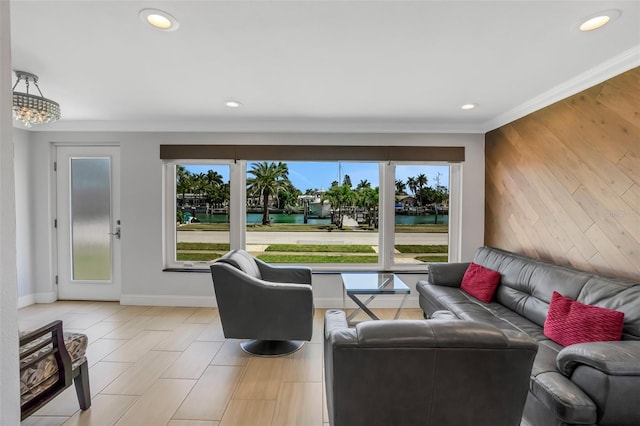 living room with crown molding, plenty of natural light, and a water view