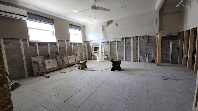 basement featuring ceiling fan, ornamental molding, and a wall mounted AC