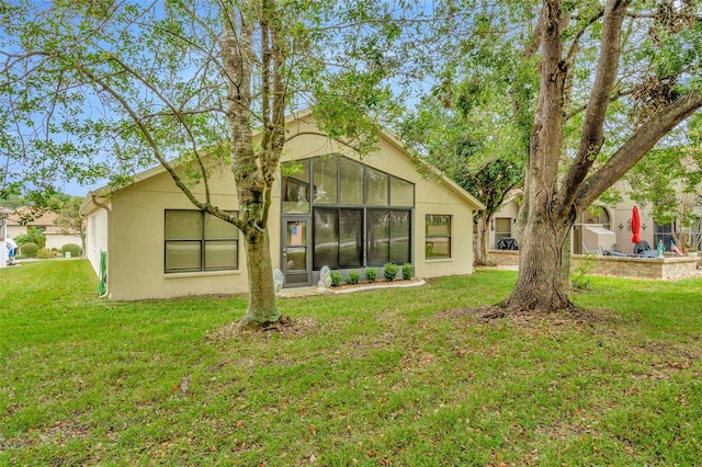 rear view of property with a sunroom and a yard