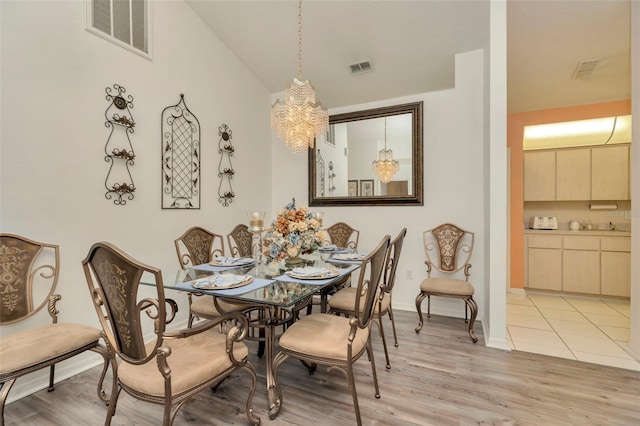 dining space with a chandelier and light hardwood / wood-style floors