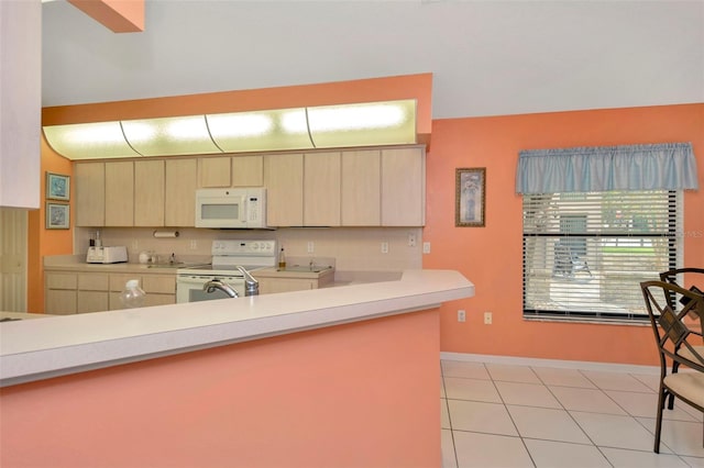 kitchen featuring kitchen peninsula, white appliances, and light tile patterned floors