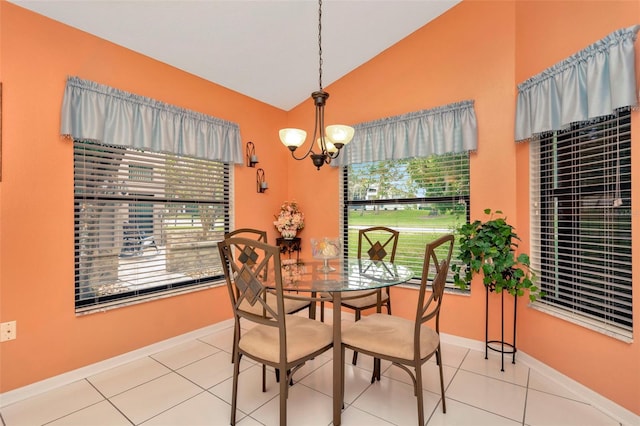 dining space with a chandelier, tile patterned floors, and vaulted ceiling