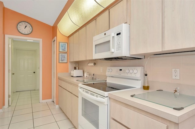 kitchen featuring light brown cabinets, white appliances, and vaulted ceiling