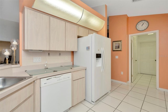 kitchen featuring decorative backsplash, light brown cabinets, light tile patterned floors, white appliances, and vaulted ceiling