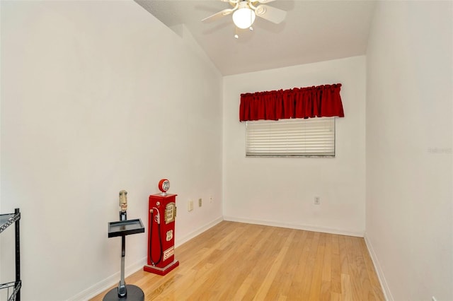 empty room with lofted ceiling, hardwood / wood-style flooring, and ceiling fan