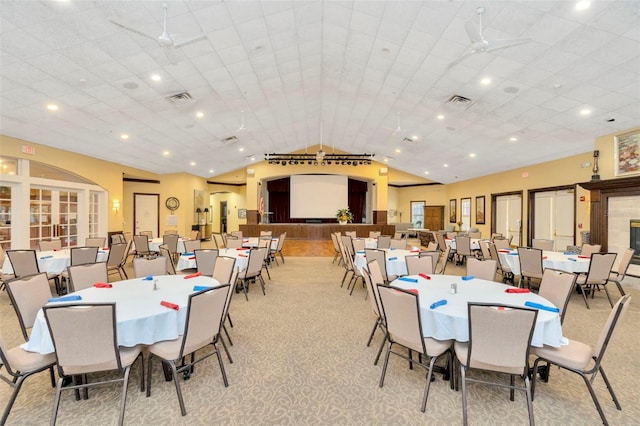 dining area featuring ceiling fan, light carpet, and lofted ceiling