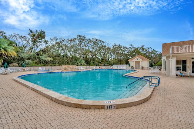 view of pool with a patio and an outdoor structure