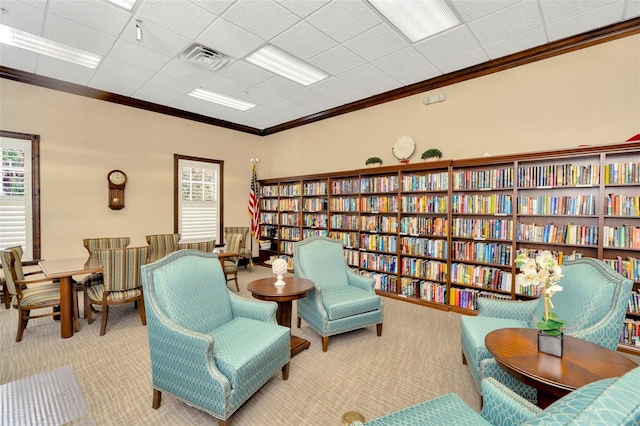 living area with a wealth of natural light, light carpet, and ornamental molding