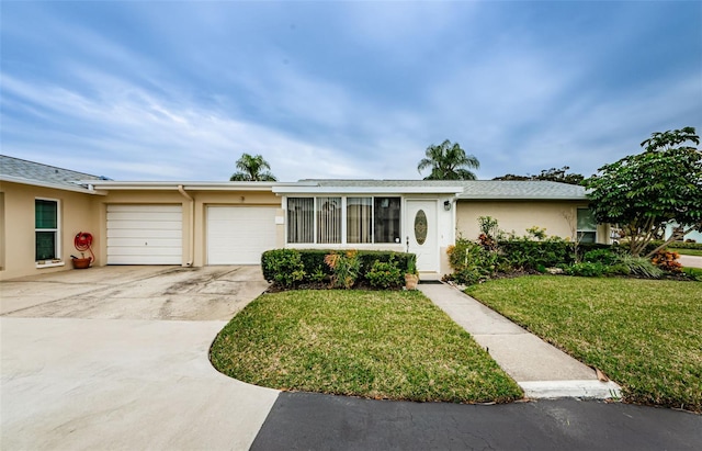 ranch-style home featuring a front lawn and a garage