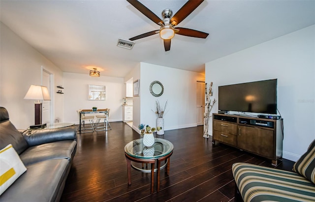 living room featuring ceiling fan and dark hardwood / wood-style floors