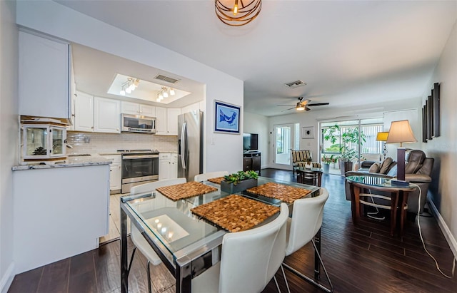 dining room with dark hardwood / wood-style floors, ceiling fan, and sink