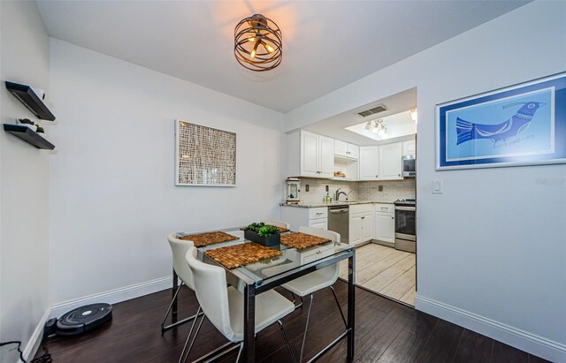 dining area with dark hardwood / wood-style flooring and sink