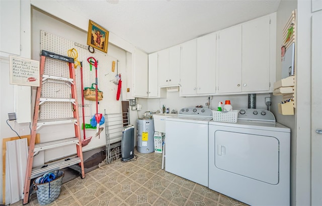 laundry room with water heater, cabinets, and washing machine and clothes dryer