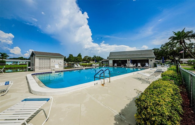 view of swimming pool with an outdoor structure and a patio area