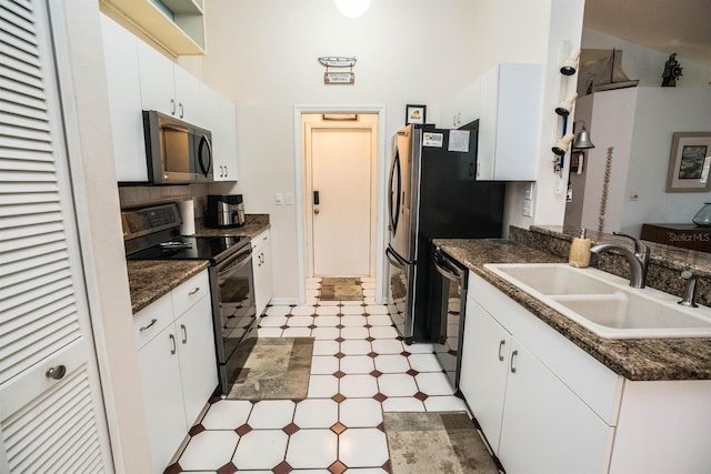 kitchen featuring white cabinetry, sink, a towering ceiling, and black appliances