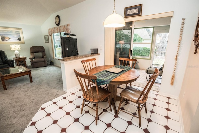 carpeted dining room featuring lofted ceiling