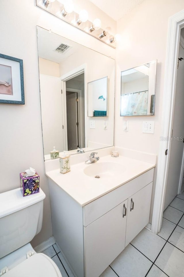 bathroom with vanity, tile patterned flooring, and toilet