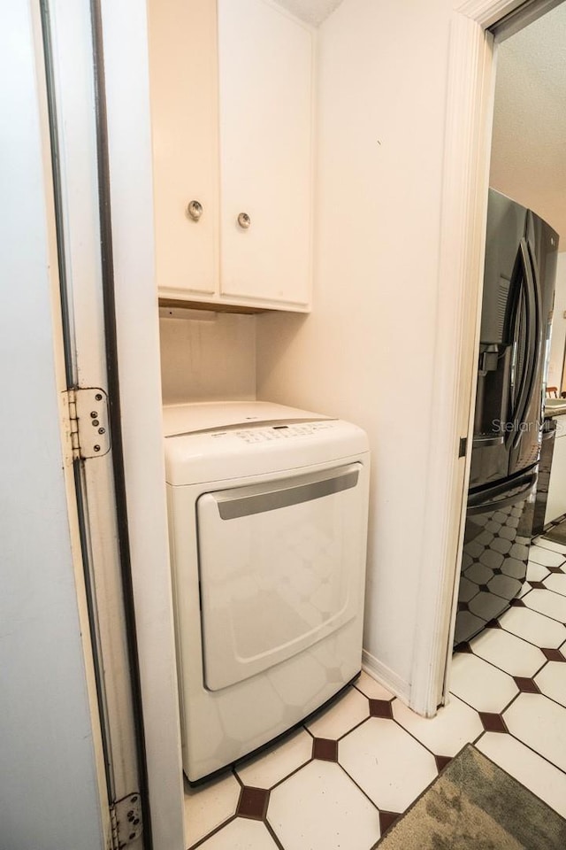 clothes washing area featuring cabinets