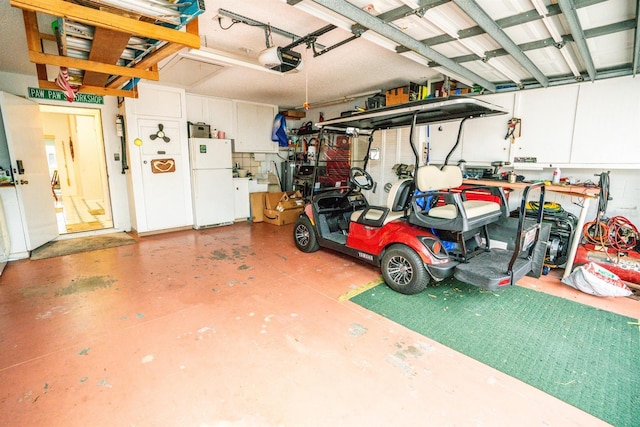 garage with a garage door opener, white fridge, and a workshop area