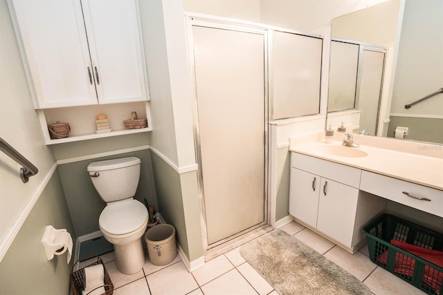 bathroom with tile patterned flooring, vanity, a shower with door, and toilet