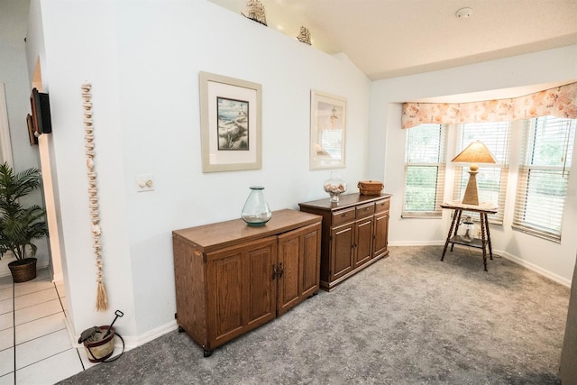 living area with light tile patterned floors and vaulted ceiling