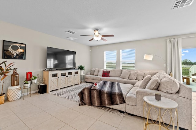 tiled living room with a textured ceiling, a wealth of natural light, and ceiling fan