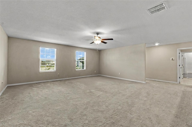 carpeted empty room featuring ceiling fan and a textured ceiling