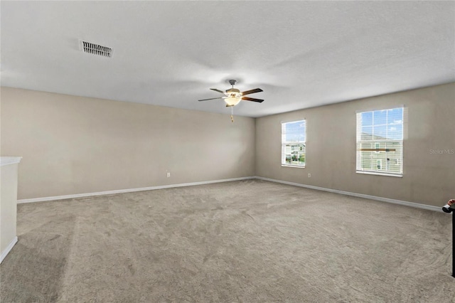 carpeted spare room featuring ceiling fan and a textured ceiling