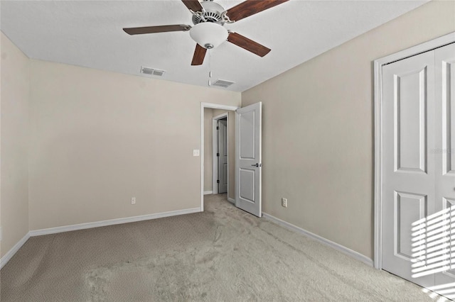 unfurnished bedroom featuring light carpet, a closet, and ceiling fan