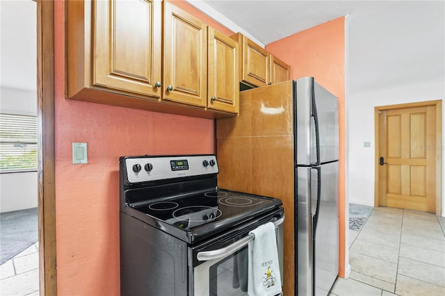 kitchen with light tile patterned floors and stainless steel range with electric cooktop