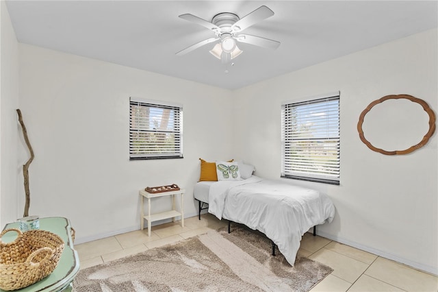 bedroom featuring multiple windows, light tile patterned floors, and ceiling fan