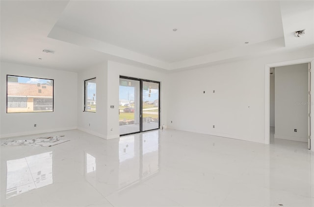 unfurnished room featuring a raised ceiling