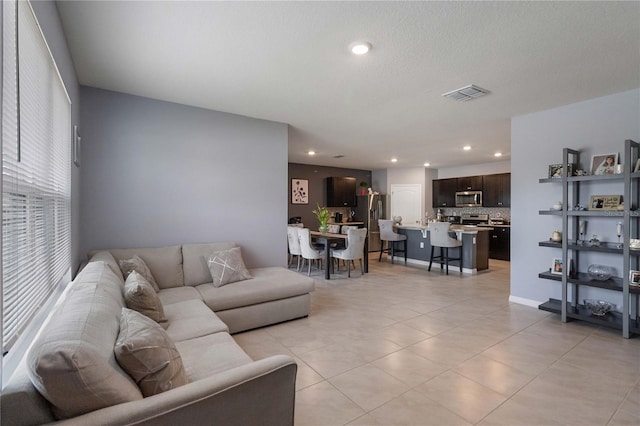 living room featuring light tile patterned flooring and a textured ceiling