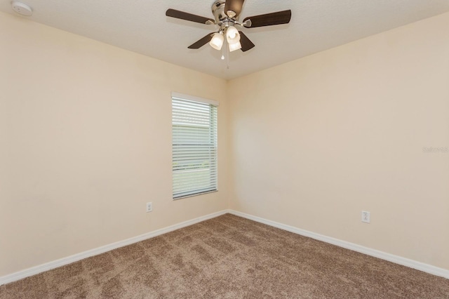 spare room featuring ceiling fan and carpet