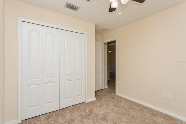 unfurnished bedroom with a closet, ceiling fan, and light colored carpet