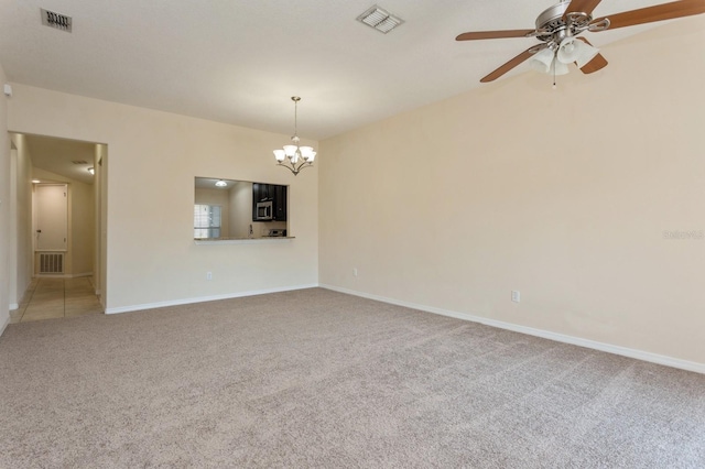 empty room featuring ceiling fan with notable chandelier and carpet floors