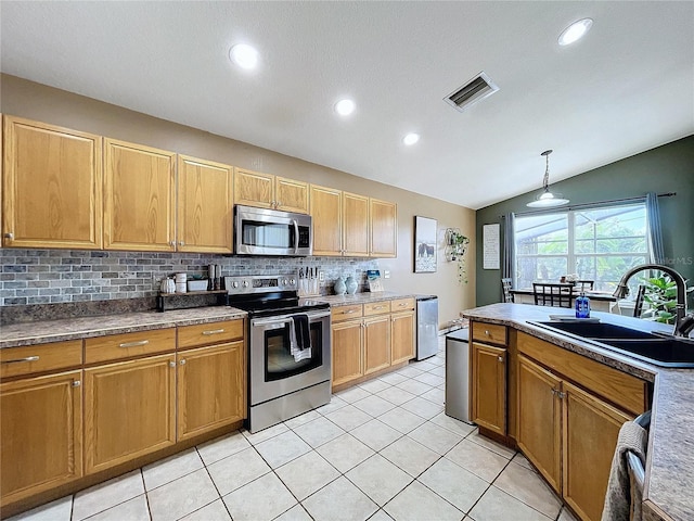 kitchen featuring lofted ceiling, backsplash, sink, hanging light fixtures, and stainless steel appliances