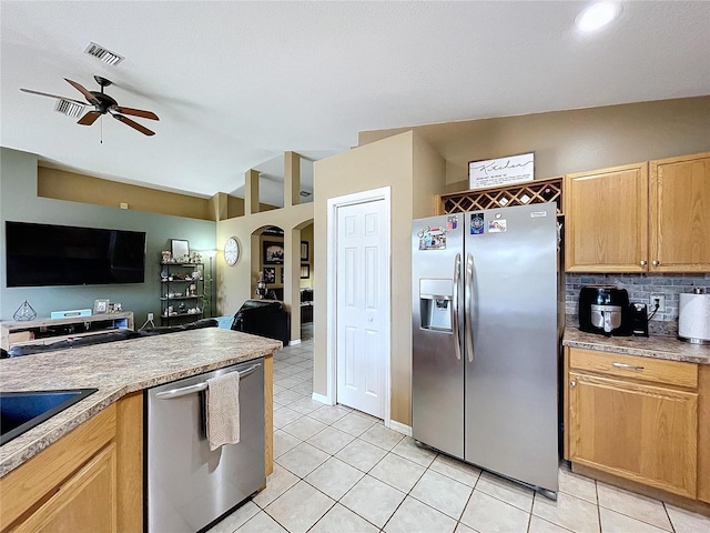 kitchen featuring ceiling fan, light tile patterned floors, stainless steel appliances, and vaulted ceiling