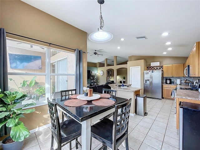 dining room featuring ceiling fan, light tile patterned flooring, and lofted ceiling