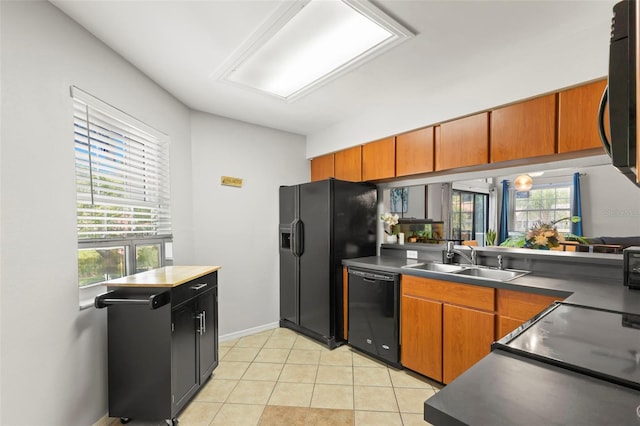 kitchen featuring black appliances, light tile patterned floors, and sink