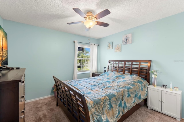 bedroom with a textured ceiling, carpet floors, and ceiling fan