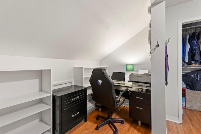 office with light hardwood / wood-style floors and lofted ceiling