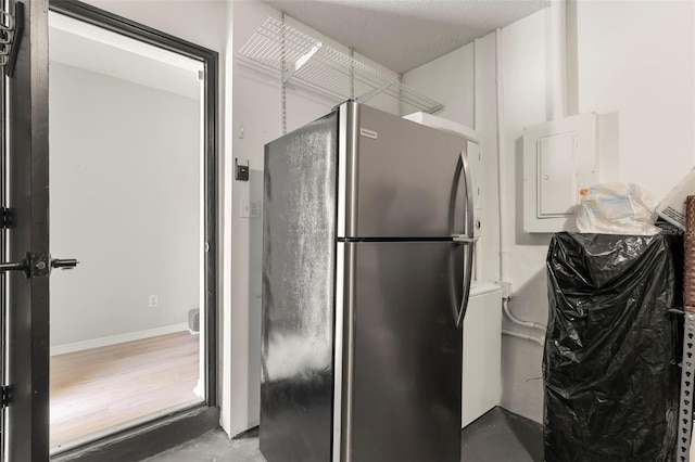 bathroom featuring concrete flooring, a textured ceiling, and electric panel