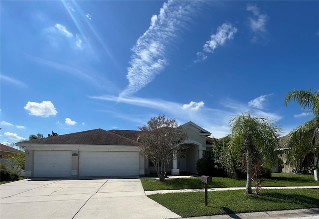 single story home featuring a front lawn and a garage