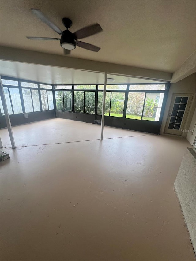 unfurnished sunroom featuring ceiling fan