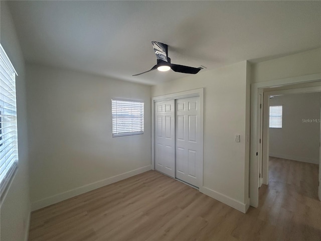 unfurnished bedroom featuring ceiling fan, light hardwood / wood-style floors, and a closet